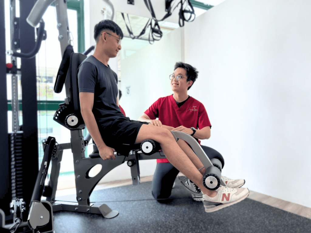 Physiotherapist in Singapore consulting a patient during a rehabilitation session using specialised physiotherapy equipment.