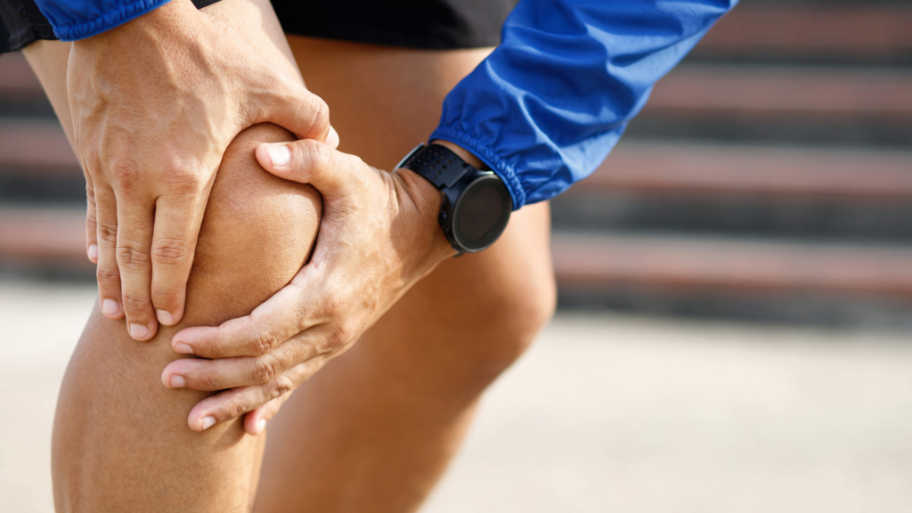 Close-up of a person gripping their knee in pain after a sports injury, highlighting the importance of proper recovery and physiotherapy for knee injuries.