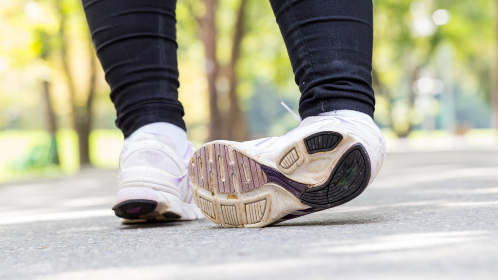 A close-up of worn-out running shoes with uneven soles, which can lead to foot pain, poor posture, and increased injury risk. Proper footwear and podiatrist-recommended insoles can help prevent foot-related issues.