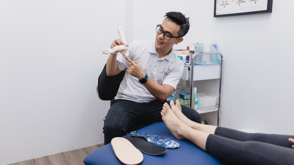 A podiatrist explaining foot biomechanics to a patient while discussing custom insole options for foot pain relief and improved support.