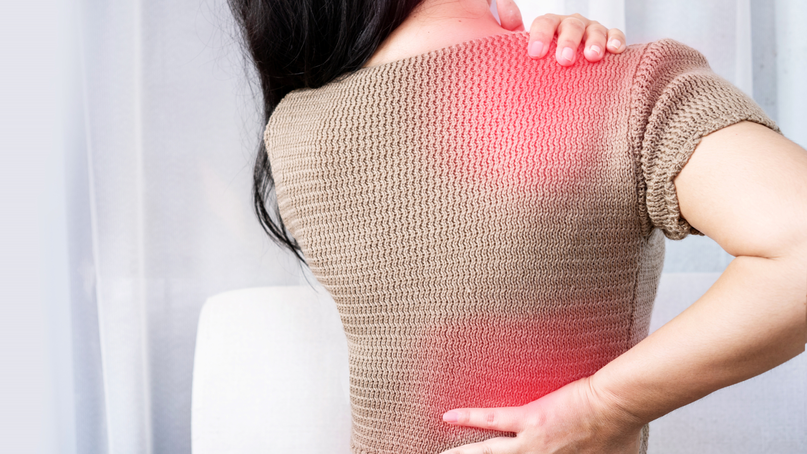 Person with long hair holding their upper back and lower back in pain, with a red highlight indicating discomfort.