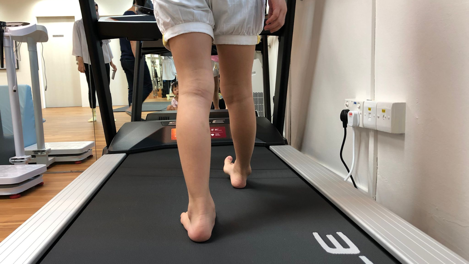 Podiatrist conducting a biomechanical assessment to evaluate foot alignment, gait, and posture as part of flatfoot treatment.