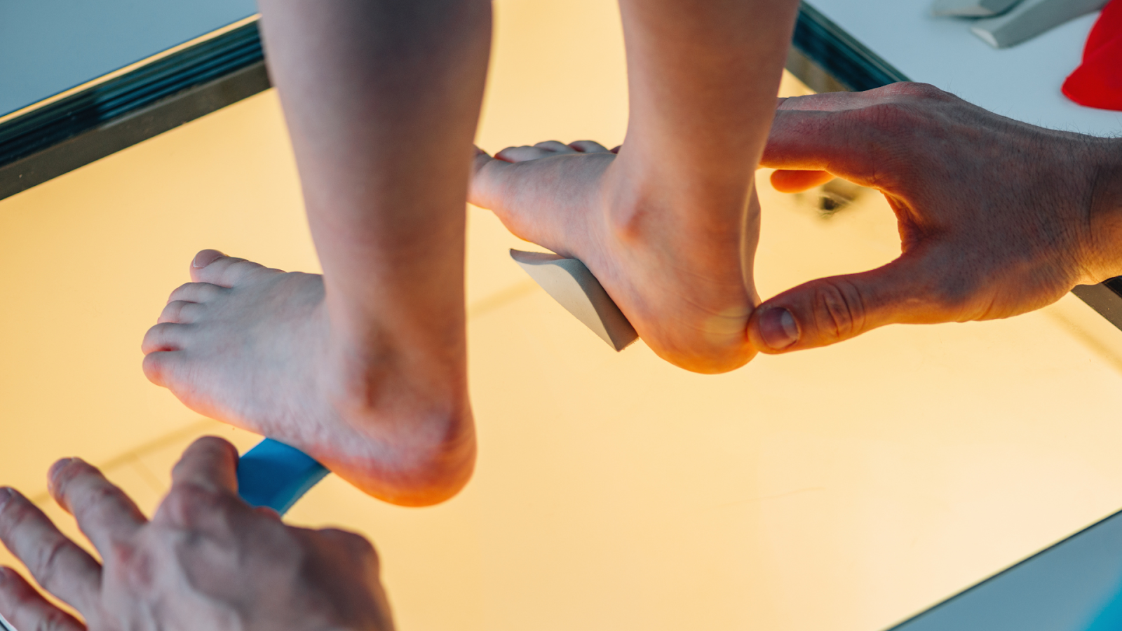 Close-up of a child’s feet being assessed using a foot scanner as part of custom insole fitting."