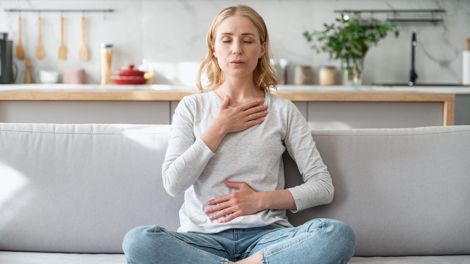 Woman practicing rotational breathing on a sofa, a core technique in Schroth Therapy for scoliosis.