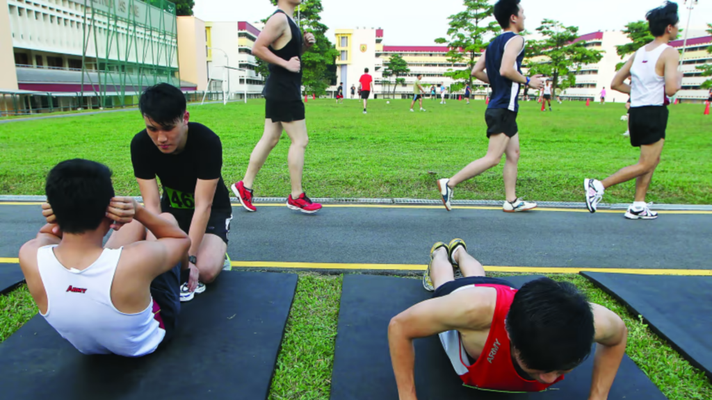 NS recruits performing sit-ups and push-ups during IPPT training, highlighting the importance of proper form and physiotherapy to avoid injuries.