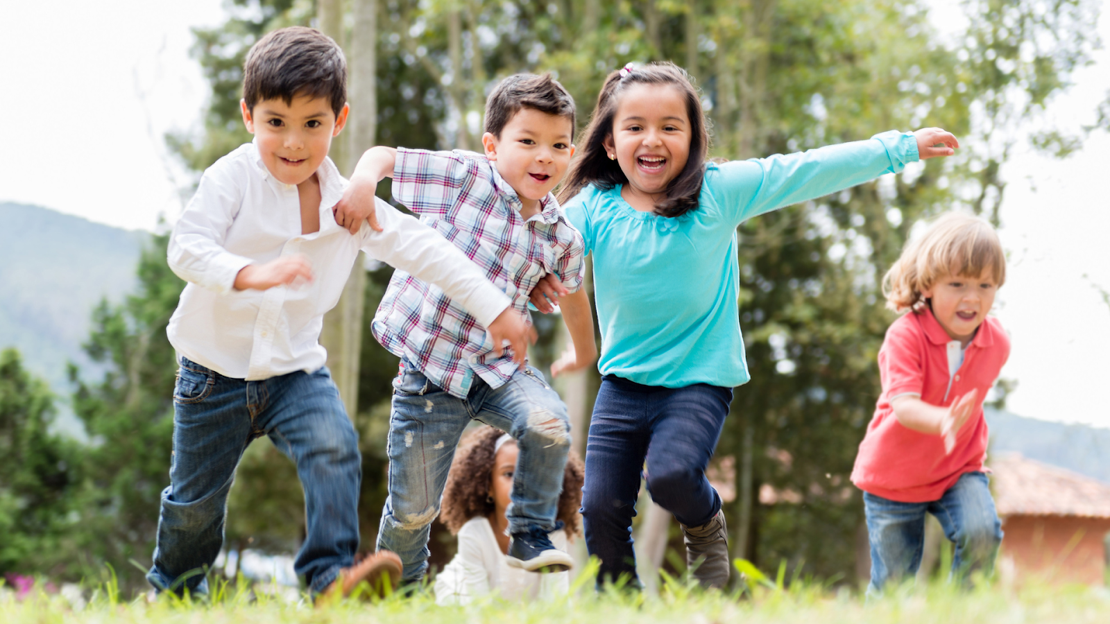 A group of children running and playing together, highlighting the importance of proper gait for active development in kids.