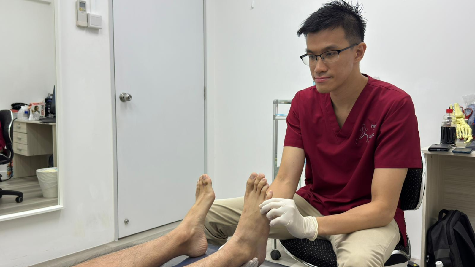 Podiatrist examining a patient’s bare foot during orthotics evaluation.
