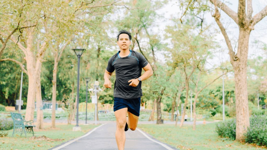 Active man jogging in a park, representing healthy exercise and recovery from Achilles tendonitis.