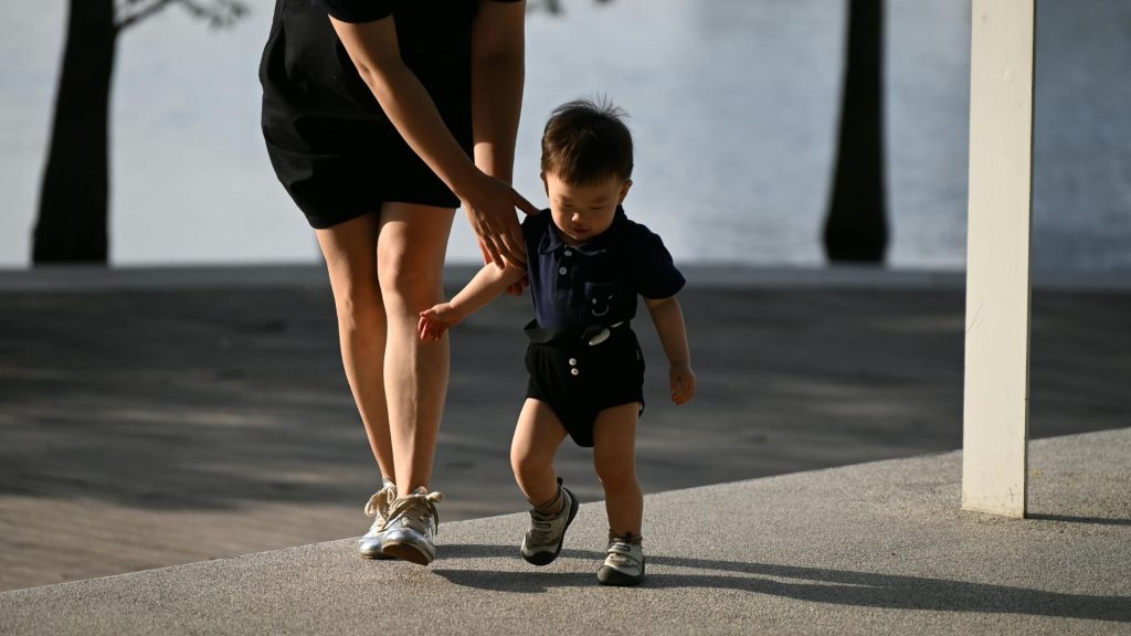 Toddler learning to walk with adult support, highlighting early foot development and balance