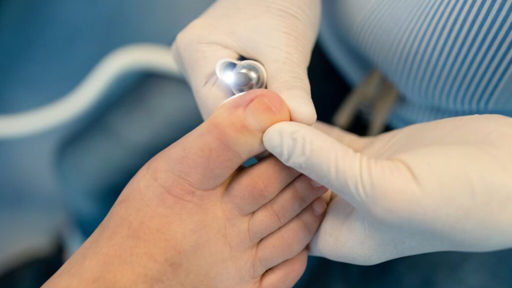 Podiatrist performing in-clinic nail fungus treatment using a specialised medical device.
