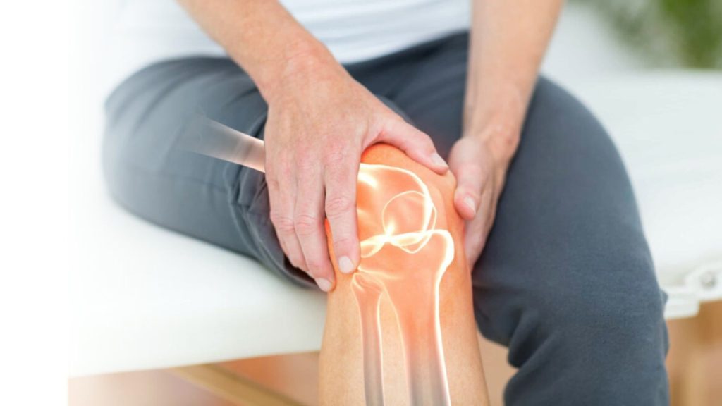 Person holding a painful knee with highlighted joint area illustrating knee osteoarthritis.