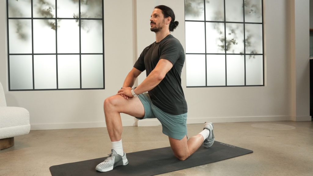 Active adult performing a kneeling lunge exercise to improve knee strength and mobility.
