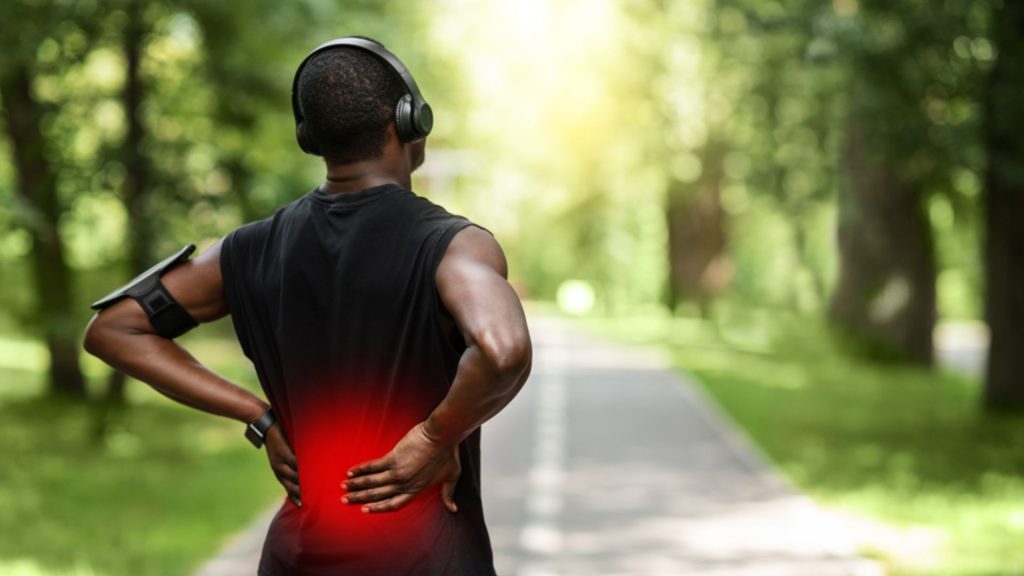 Runner experiencing lower back pain due to repeated loading and training demands
