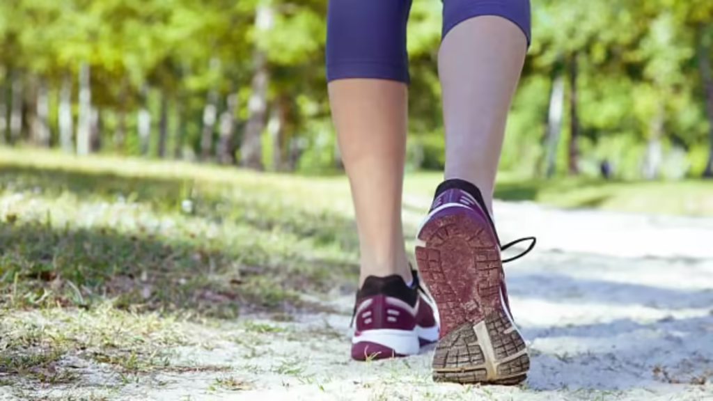 Person walking outdoors on a trail, highlighting lower limb movement during regular walking.