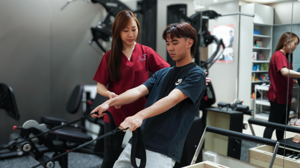 Physiotherapist supervising a patient performing a resistance exercise as part of rehabilitation.