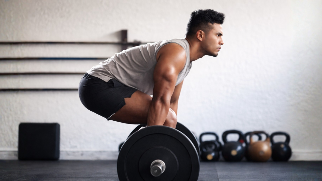 Man clenching jaw while deadlifting, demonstrating gym-related jaw tension.