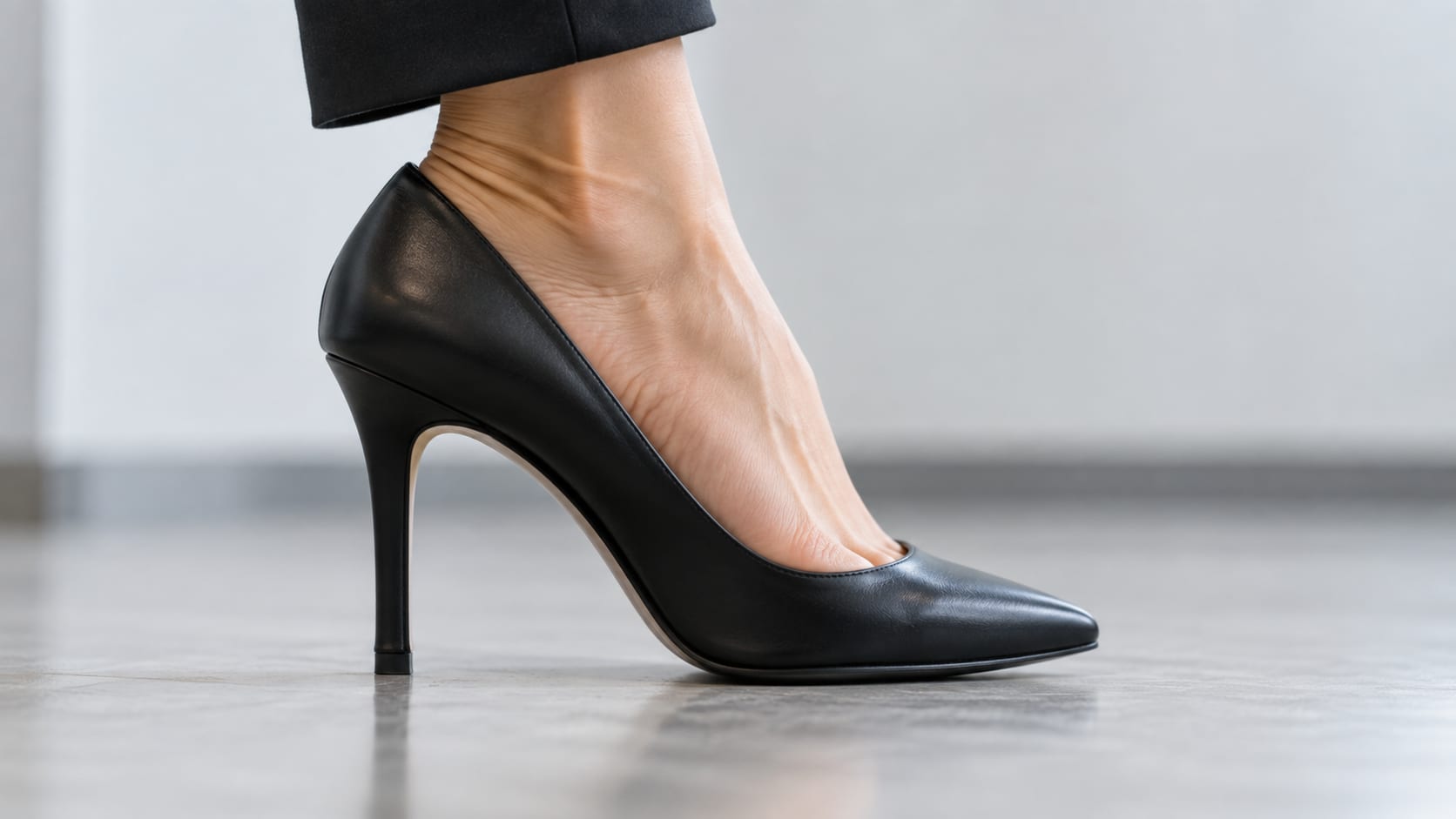 Side view of a foot in a black pointed stiletto heel
