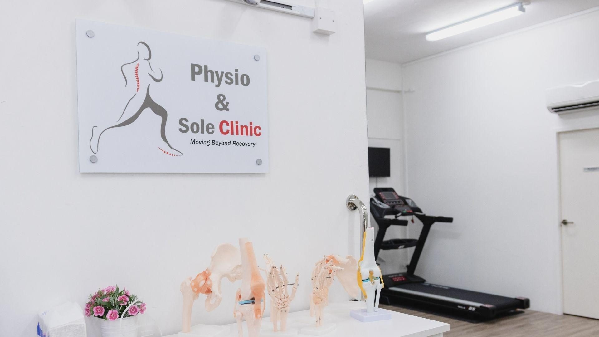 Physio & Sole Clinic sign on a wall beside anatomical joint models and a treadmill