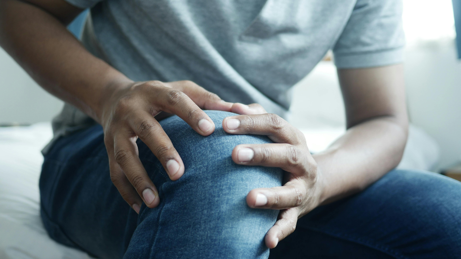 Active adult experiencing knee pain, seeking treatment from a sports physiotherapist in Singapore