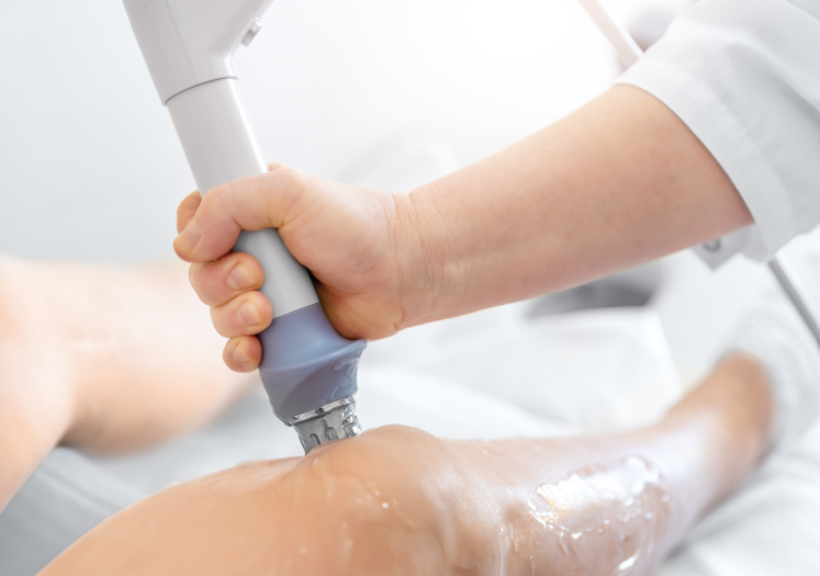 a person applying gel with a machine. shockwave therapy