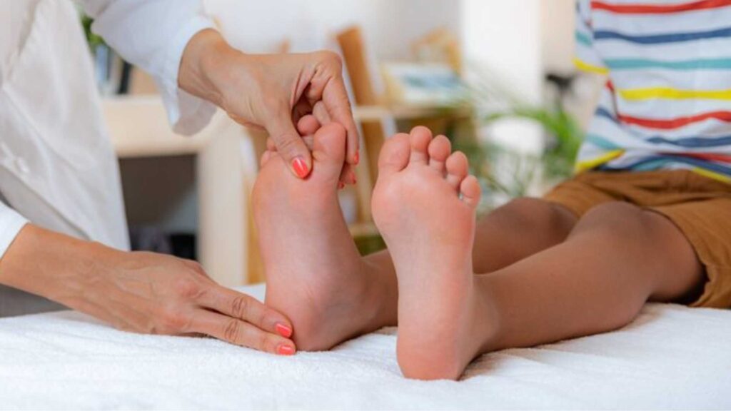 A podiatrist performing a paediatric feet assessment on a young child's feet to evaluate alignment and health.