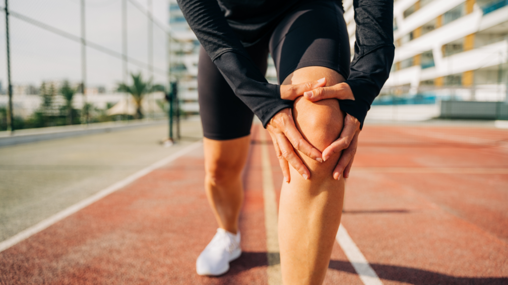 Woman clutching her knee due to pain from playing pickleball
