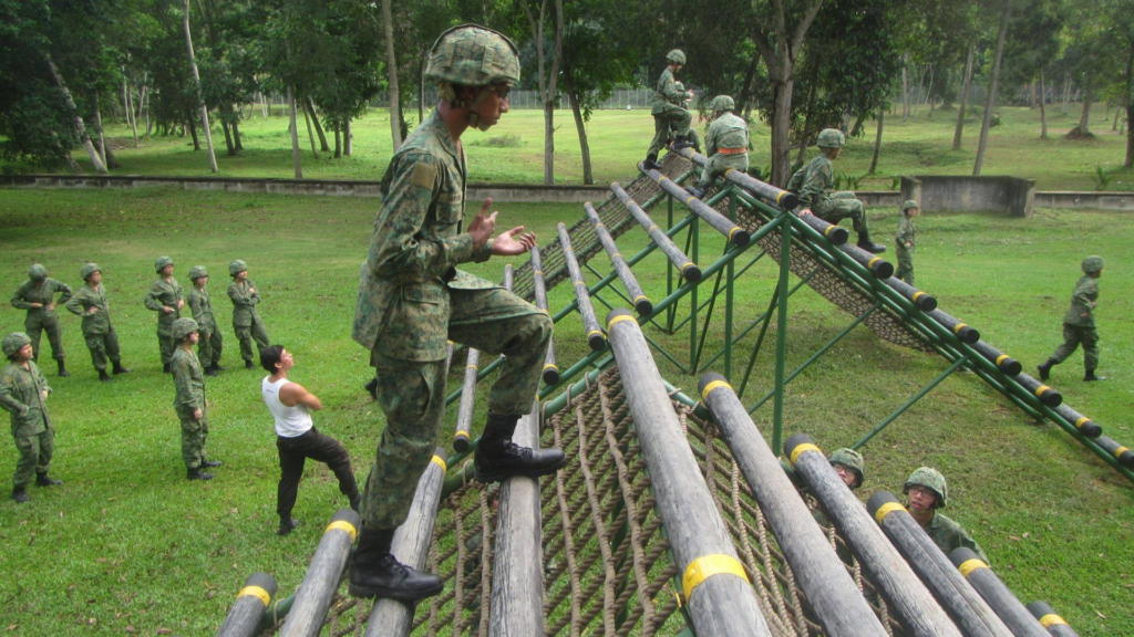 NS recruits navigating an obstacle course during BMT training in Singapore, where proper form and physio support can help prevent common injuries.