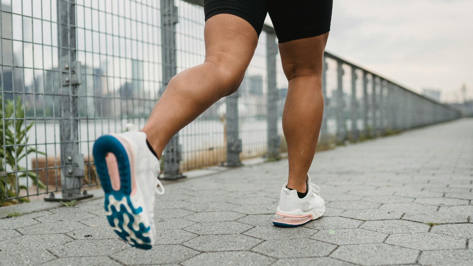 Rear view of a person running in sports shoes, symbolising recovery from knee pain.