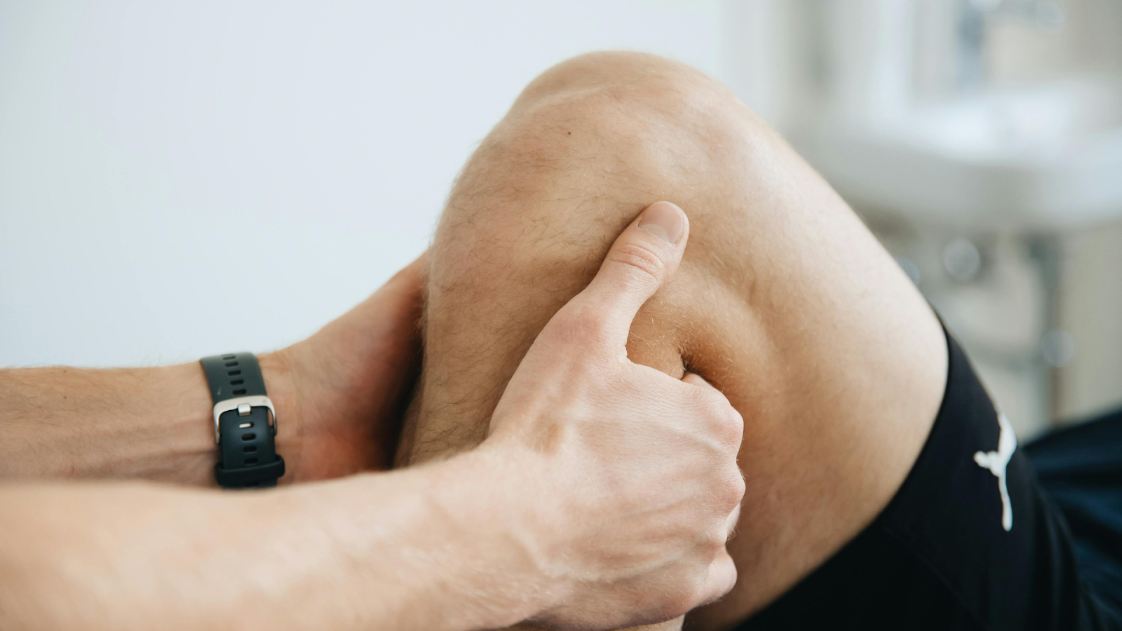 Hands assessing a senior's knee for joint pain – musculoskeletal evaluation for older adults