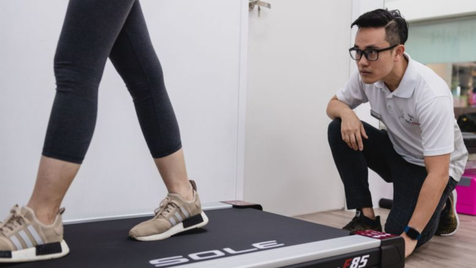 Podiatrist observing gait analysis on treadmill to assess osteoarthritis-related foot issues.