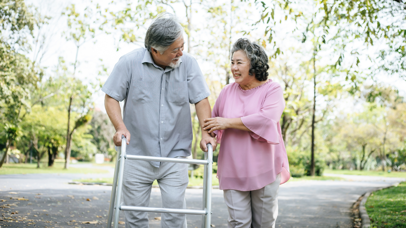 Older man using a walking aid outdoors with spouse – mobility support for foot and knee pain