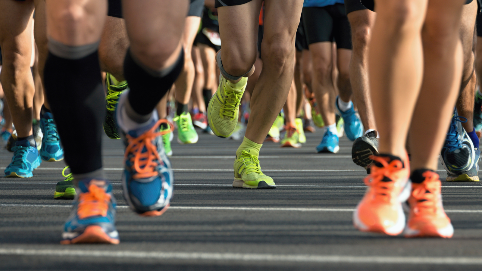 Close-up of athletes running with various sports shoes, highlighting the need for custom insoles for sports performance