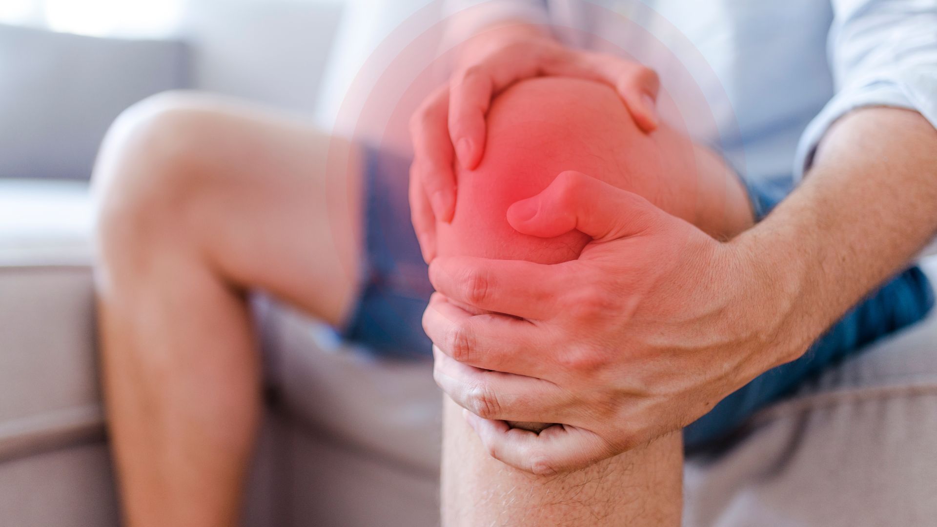 Man holding knee in pain from arthritis, highlighting need for physiotherapy intervention.