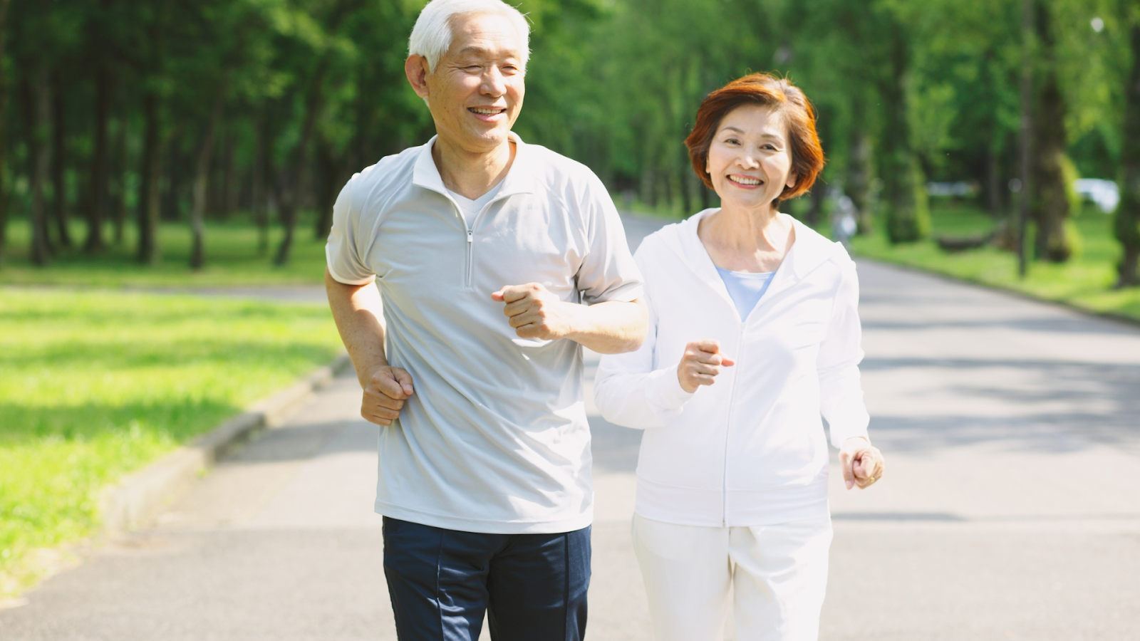 Elderly couple enjoying a walk in the park after arthritis treatment and physiotherapy support.