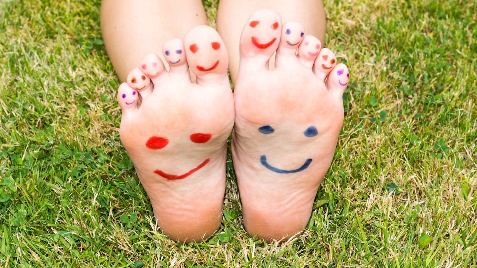 Happy children's feet with smiley faces drawn on toes, symbolising healthy feet