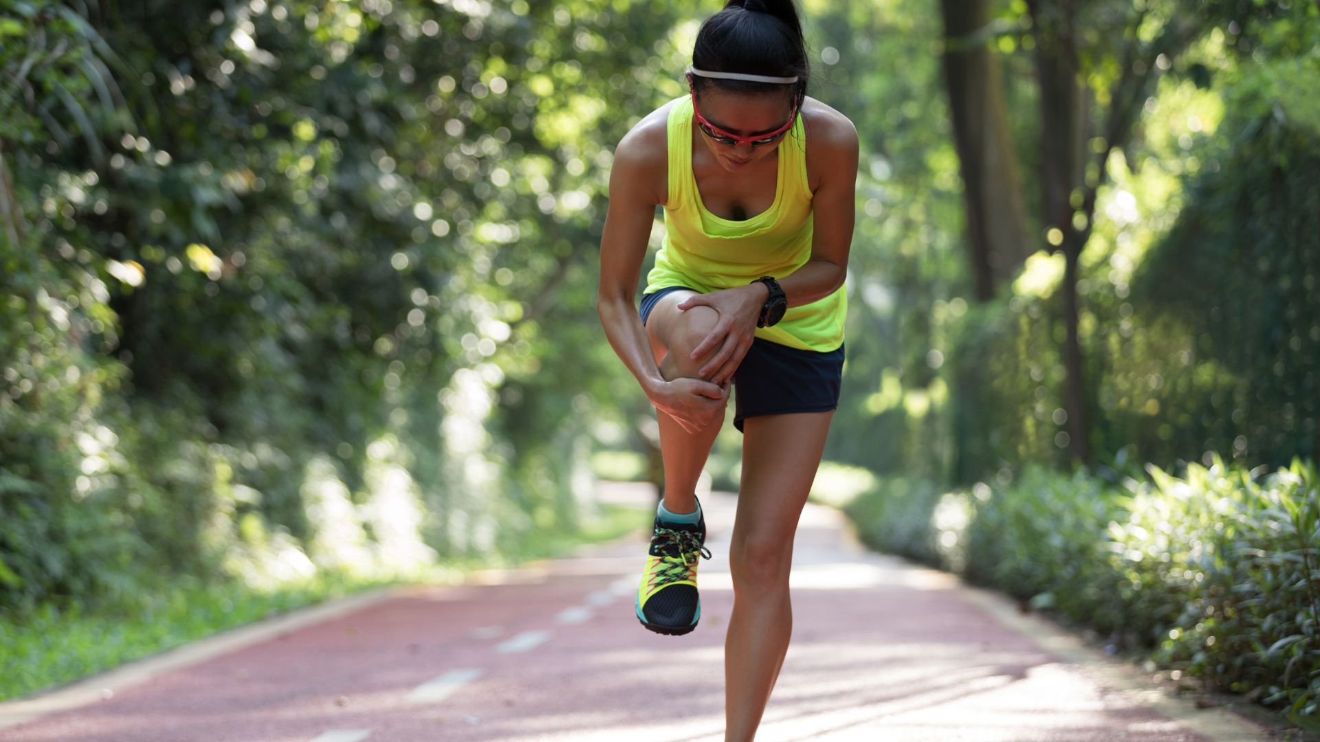 Female runner experiencing sharp knee pain linked to patellofemoral pain syndrome