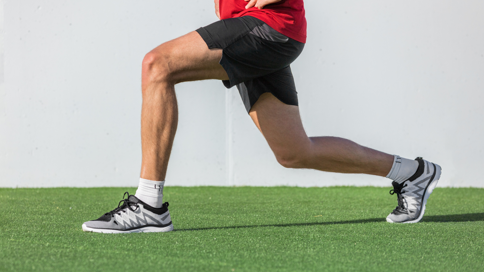 Athlete performing a stretching lunge, part of rehab exercises for ankle strength and mobility.