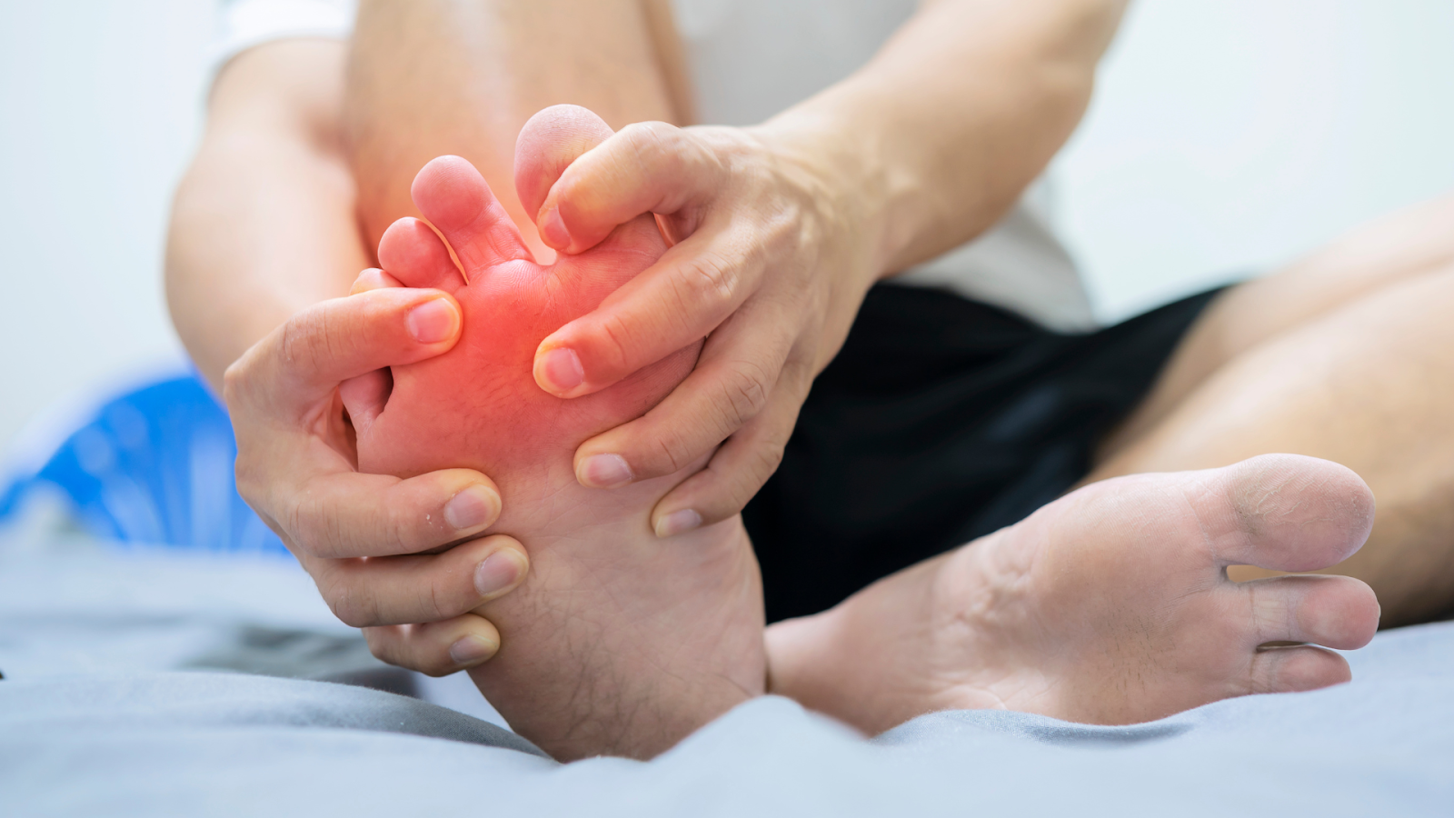 Pressing the ball of the foot due to nerve pain, a symptom of Morton's Neuroma.