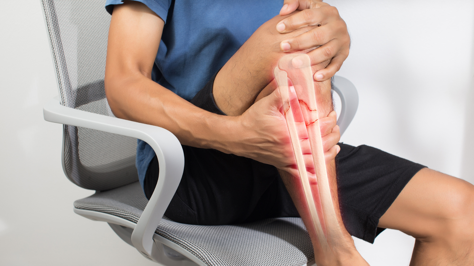 Person sitting and holding shin in pain, highlighted bone showing fracture.
