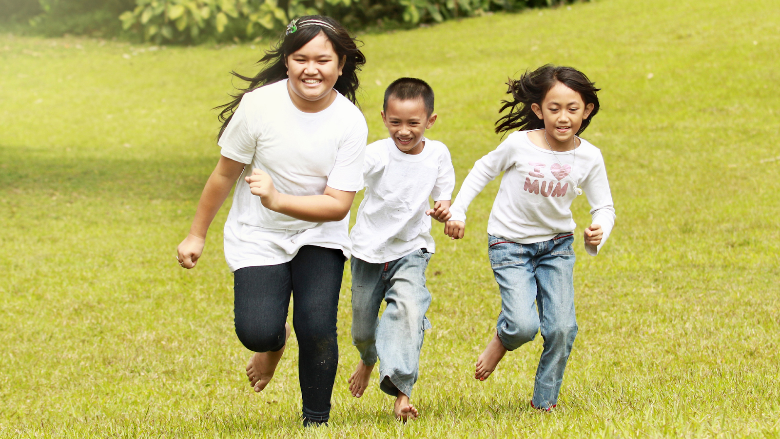 Children happily running barefoot on grass, symbolizing mobility and freedom post-treatment.