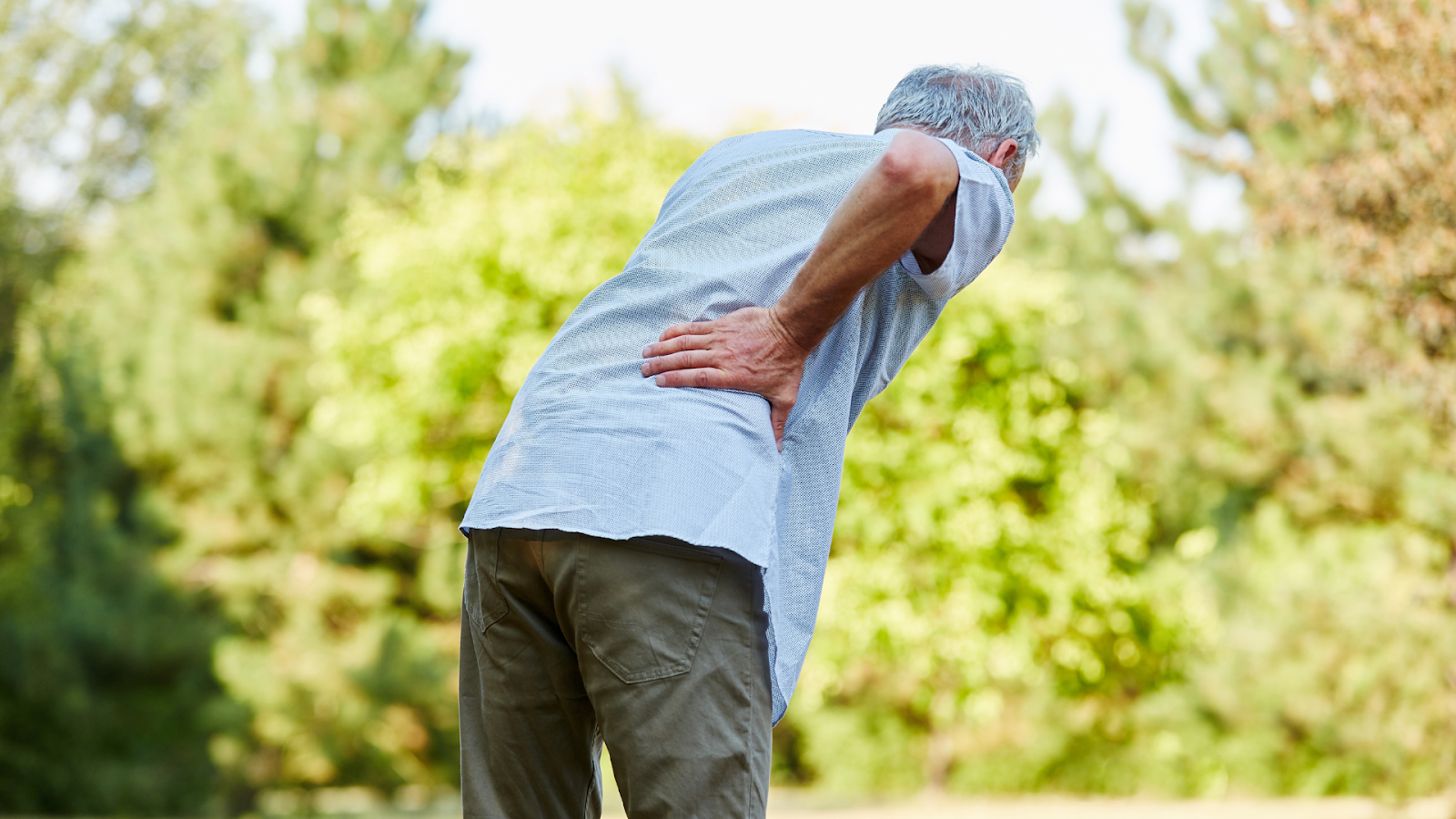 Senior man with back pain due to osteoporosis or spinal degeneration