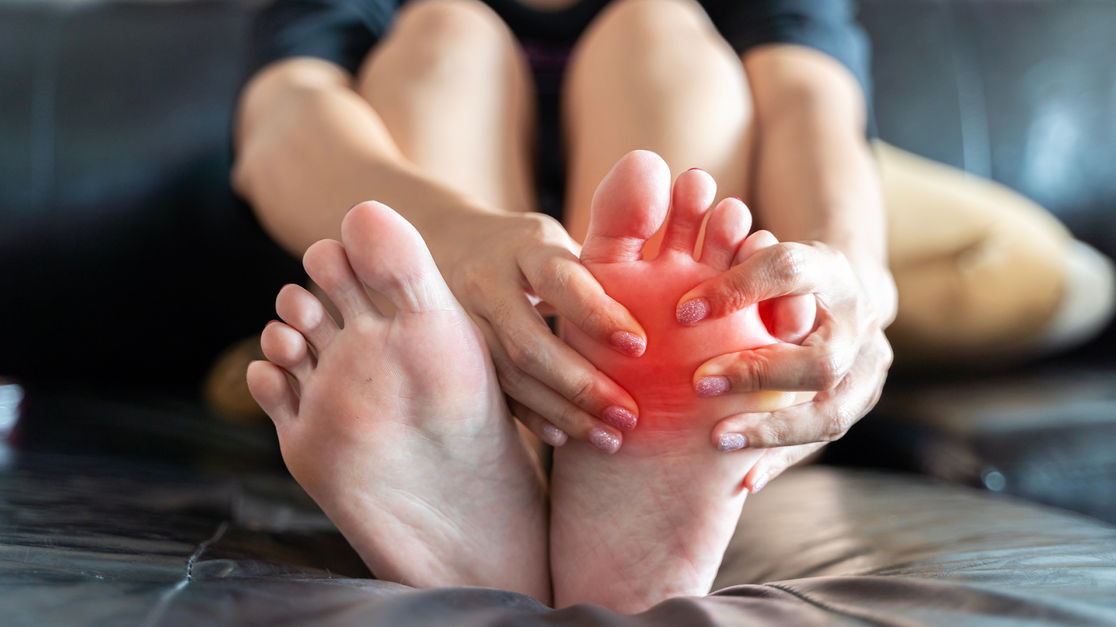 Woman holding foot in pain, a common symptom of Morton's Neuroma.