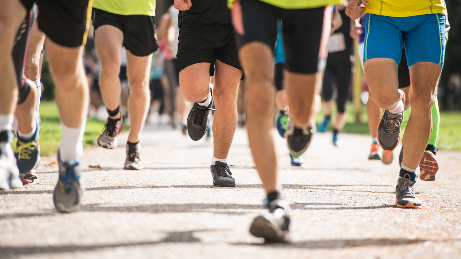 Close-up of marathon runners’ legs and feet in motion during a race, highlighting the importance of proper foot care and footwear for long-distance running in Singapore.