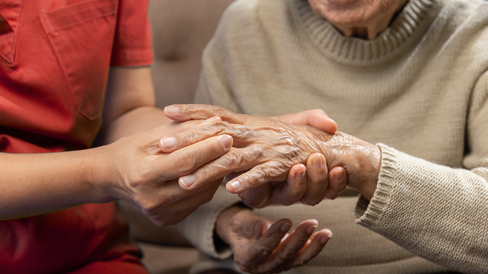 Physiotherapist gently examining senior patient’s arthritic hand