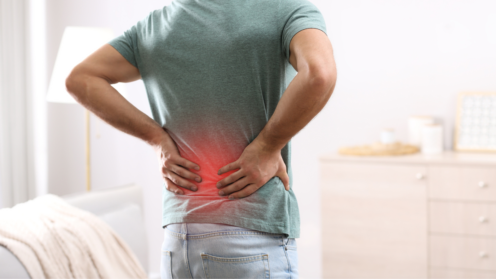 Person holding lower back in pain, highlighting possible posture or foot alignment issues.