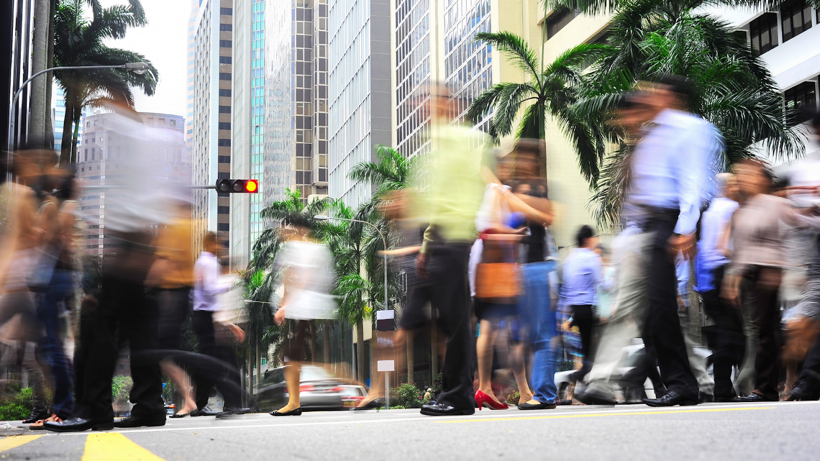 Blurred crowd crossing the street in Singapore’s Central Business District.