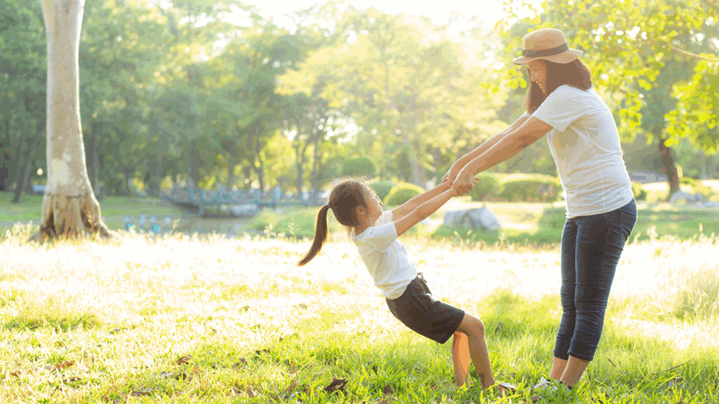 Mother swinging daughter in the park after reassurance about pigeon toe