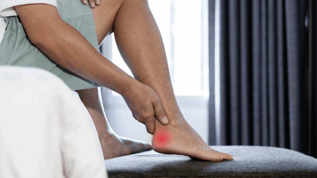 Close-up of man holding ankle with red inflamed Achilles tendon, showing symptoms of tendonitis.