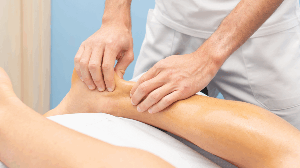 Physiotherapist performing manual therapy on the Achilles tendon to relieve pain and support healing.