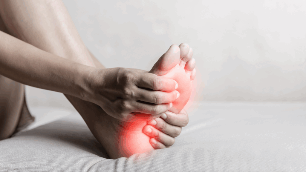 Person holding the arch of their foot with red pain highlight, indicating plantar fasciitis